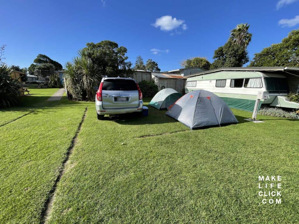 Haval H9 parked in campsite with tents next to it.